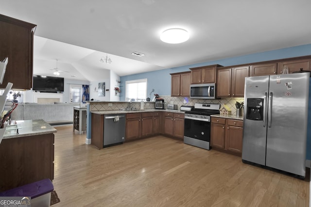 1885 Hickory Station Cir, Snellville, GA 30078 - kitchen with appliances with stainless steel finishes, light wood-style floors, a sink, open floor plan, and decorative backsplash