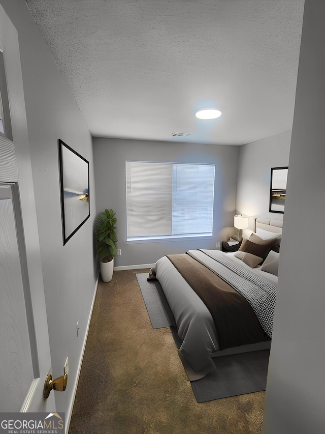 carpeted bedroom with baseboards and a textured ceiling