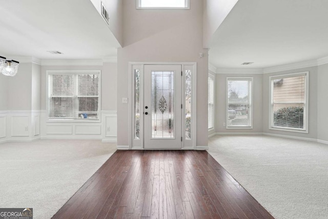 1736 Dylan Pl, Lawrenceville, GA 30043 - foyer featuring ornamental molding, dark wood-type flooring, wainscoting, a decorative wall, and dark colored carpet