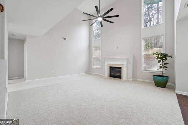 1736 Dylan Pl, Lawrenceville, GA 30043 - unfurnished living room with high vaulted ceiling, ceiling fan, a premium fireplace, and carpet