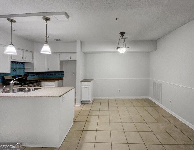 219 Cobblestone Trl, Avondale Estates, GA 30002 - kitchen featuring white cabinets, tasteful backsplash, hanging light fixtures, a peninsula, and a sink