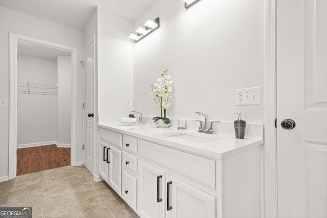 full bathroom featuring double vanity and a walk in closet