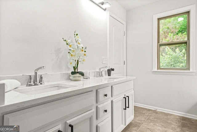 full bathroom with double vanity and baseboards