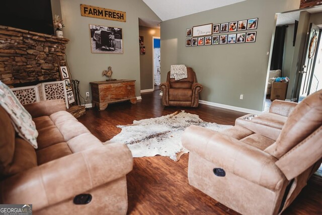 living room with lofted ceiling, baseboards, and wood finished floors