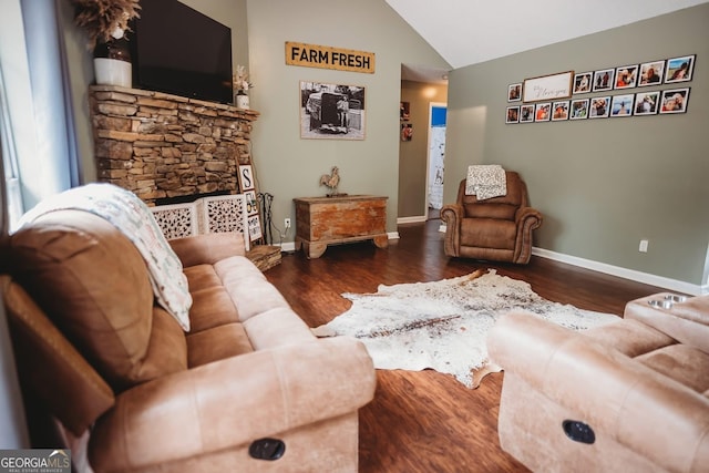 living area featuring lofted ceiling, wood finished floors, and baseboards