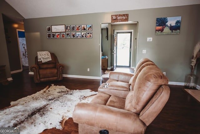 living room featuring baseboards, wood finished floors, and vaulted ceiling
