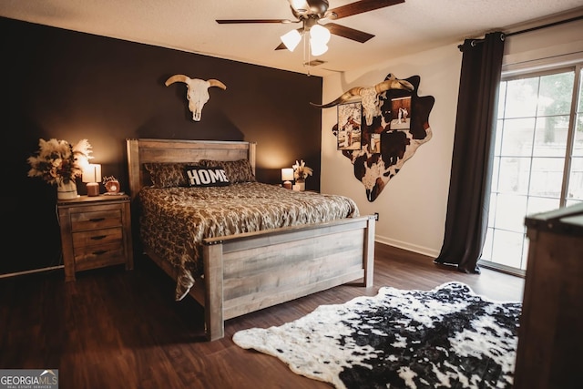 bedroom with dark wood-type flooring, a ceiling fan, and baseboards