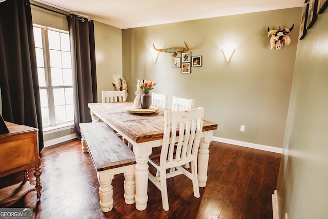 dining area featuring dark wood-style flooring and baseboards