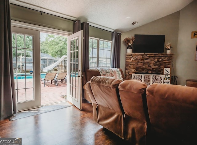 living room with vaulted ceiling, wood finished floors, a textured ceiling, and french doors