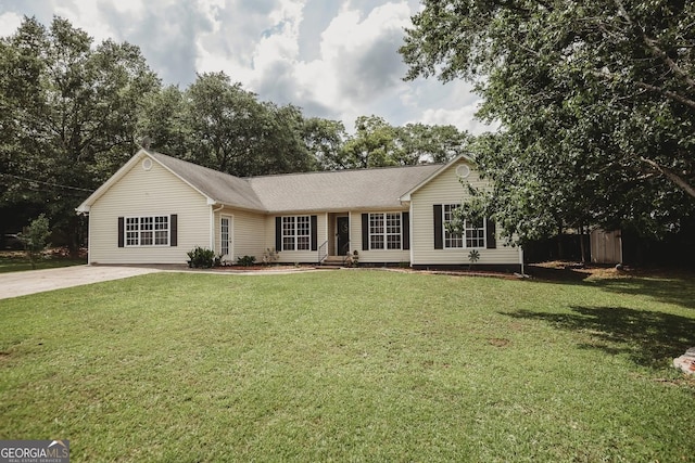 ranch-style home with a front yard and concrete driveway