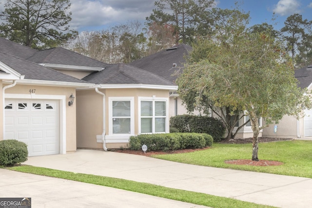 447 Eagle Blvd, Kingsland, GA 31548 - view of front of home featuring a garage, stucco siding, concrete driveway, a front lawn, and roof with shingles