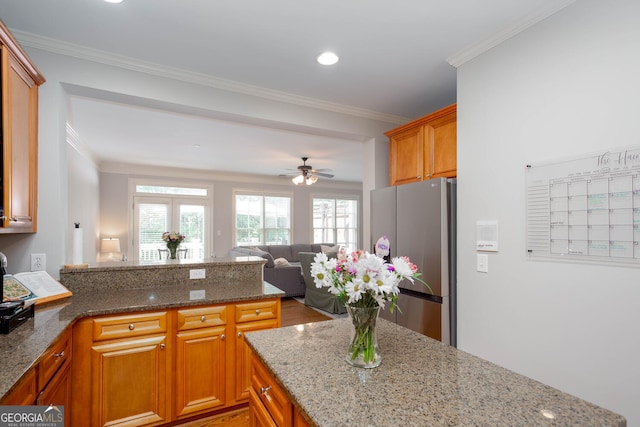 855 Mountain View Ter NW, Marietta, GA 30064 - kitchen with freestanding refrigerator, open floor plan, light stone countertops, a peninsula, and crown molding