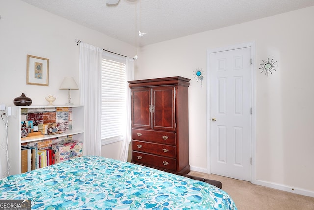 carpeted bedroom with baseboards and a textured ceiling