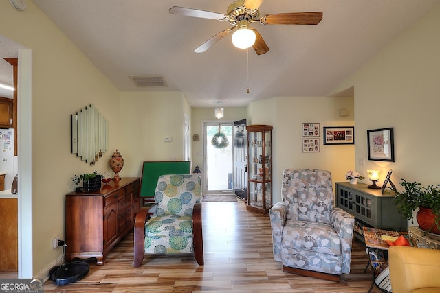 living area featuring light wood finished floors and a ceiling fan
