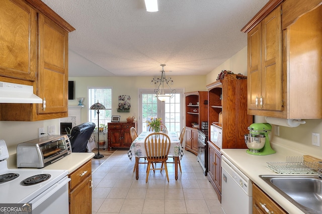 kitchen featuring white appliances, extractor fan, a sink, brown cabinets, and light tile patterned flooring