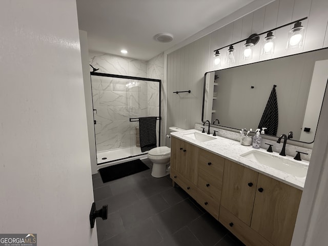 full bathroom featuring toilet, a marble finish shower, double vanity, and tile patterned floors