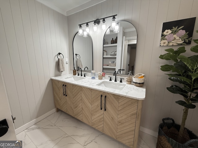 full bathroom with marble look tiles, baseboards, double vanity, crown molding, and wooden walls