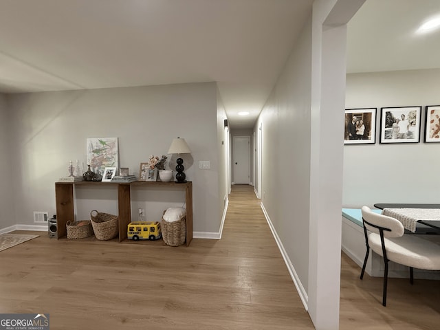 hallway with light wood-style flooring and baseboards