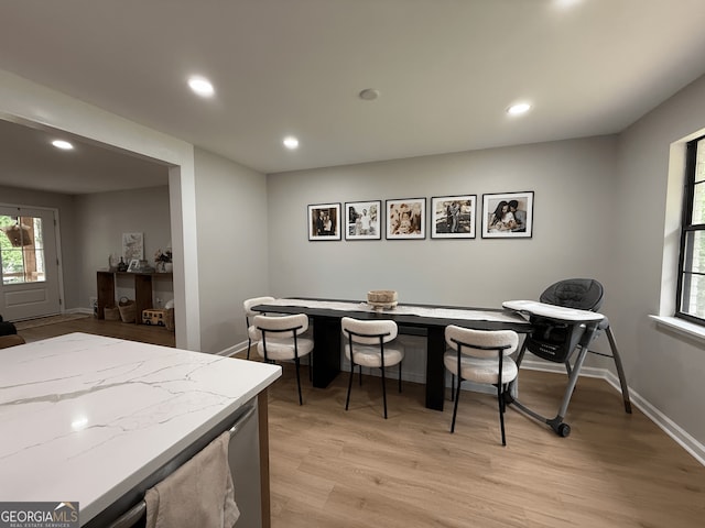 dining room featuring light wood finished floors, recessed lighting, and baseboards