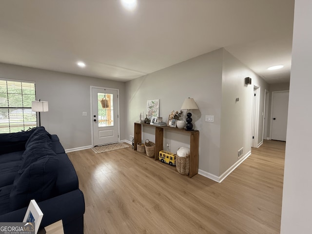 living area featuring light wood-type flooring, baseboards, healthy amount of natural light, and recessed lighting