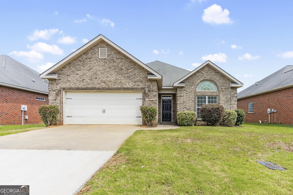 view of front of house with brick siding, a garage, concrete driveway, and a front lawn