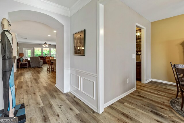 733 Firefly Ct, Griffin, GA 30223 - hall with wood finished floors, crown molding, arched walkways, and baseboards