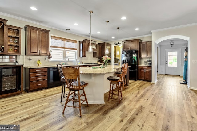733 Firefly Ct, Griffin, GA 30223 - kitchen with black appliances, beverage cooler, arched walkways, a kitchen breakfast bar, and backsplash