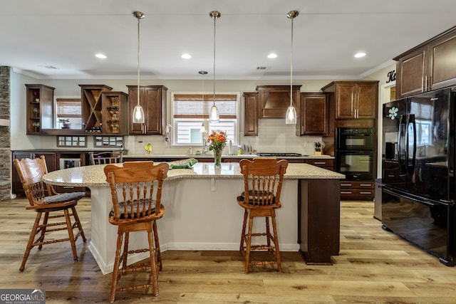 733 Firefly Ct, Griffin, GA 30223 - kitchen with black appliances, dark brown cabinetry, a center island, decorative backsplash, and crown molding