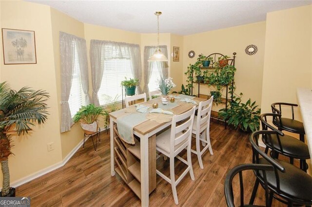 dining room featuring dark wood-style floors and baseboards