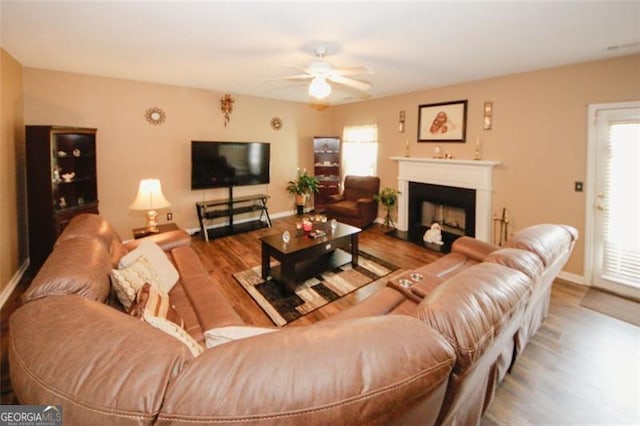 living room featuring a ceiling fan, healthy amount of natural light, and wood finished floors