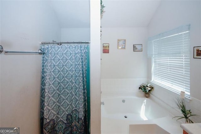 full bath featuring a bath, a shower with curtain, and vaulted ceiling