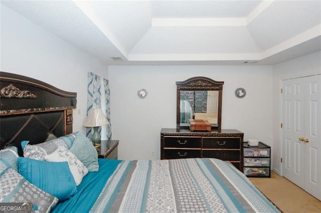 carpeted bedroom with a raised ceiling