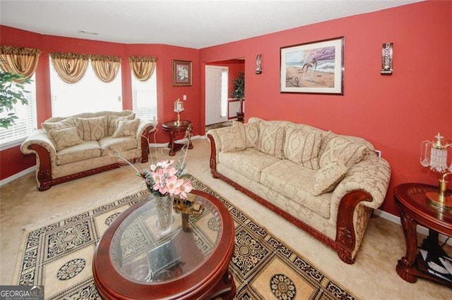 carpeted living room with healthy amount of natural light and baseboards