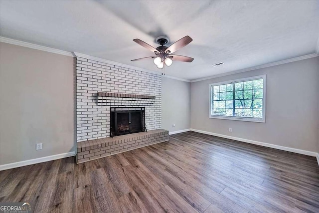 unfurnished living room featuring a ceiling fan, wood finished floors, baseboards, a brick fireplace, and ornamental molding