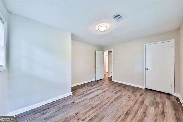unfurnished bedroom featuring wood finished floors and baseboards