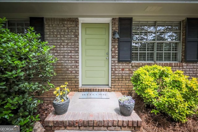 entrance to property with brick siding and covered porch