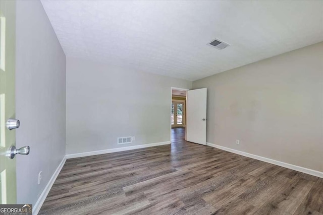 spare room with wood finished floors and baseboards