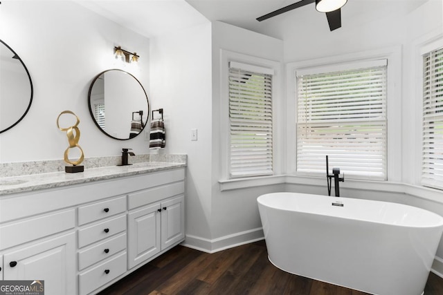 1560 Parks Mill Dr, Greensboro, GA 30642 - bathroom with a ceiling fan, wood finished floors, baseboards, a freestanding bath, and double vanity