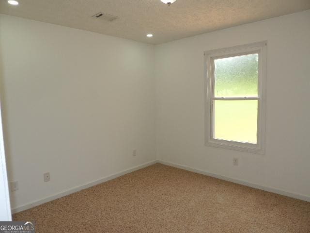 unfurnished room with light carpet, recessed lighting, and baseboards