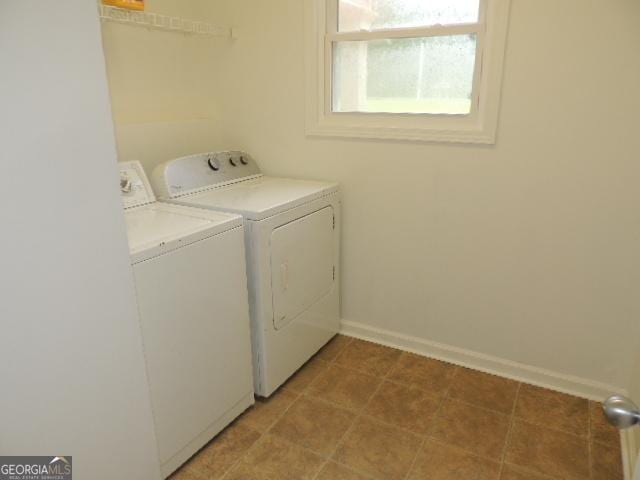 washroom with washing machine and clothes dryer and baseboards