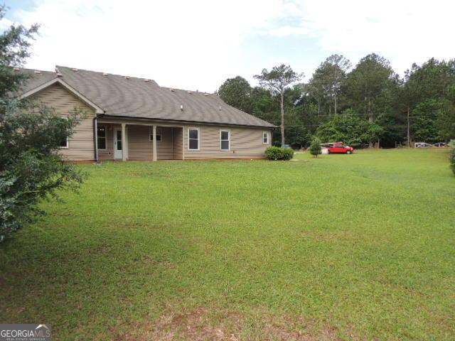 rear view of house featuring a lawn