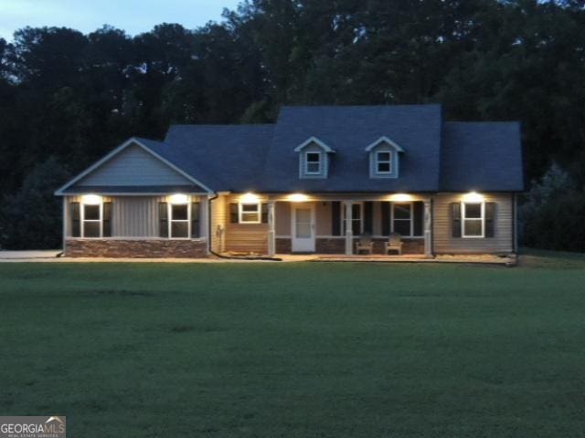 cape cod-style house with a porch and a front lawn