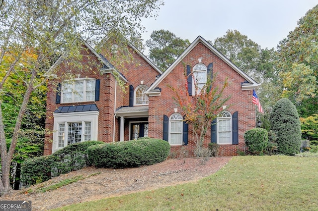 3565 Hickory Branch Trl, Suwanee, GA 30024 - view of front facade featuring a front yard, brick siding, and a standing seam roof