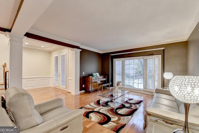 3565 Hickory Branch Trl, Suwanee, GA 30024 - living room with ornate columns, light wood-style flooring, ornamental molding, a wainscoted wall, and a decorative wall