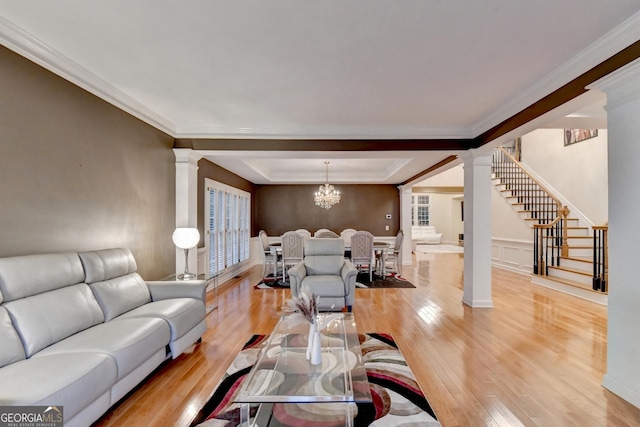 3565 Hickory Branch Trl, Suwanee, GA 30024 - living area featuring decorative columns, light wood-style flooring, stairway, a raised ceiling, and ornamental molding