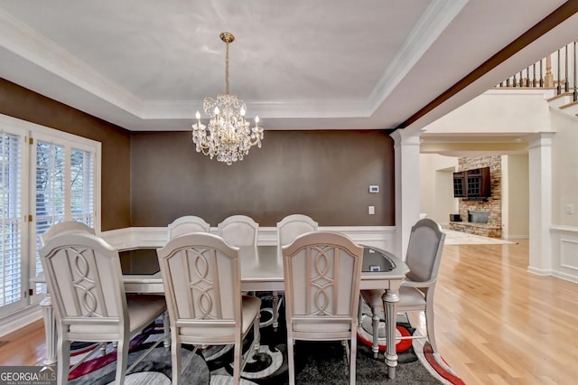 3565 Hickory Branch Trl, Suwanee, GA 30024 - dining space featuring a chandelier, a tray ceiling, light wood finished floors, crown molding, and a wainscoted wall