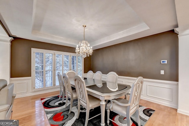 3565 Hickory Branch Trl, Suwanee, GA 30024 - dining room with a tray ceiling, a decorative wall, a chandelier, wood finished floors, and a wainscoted wall