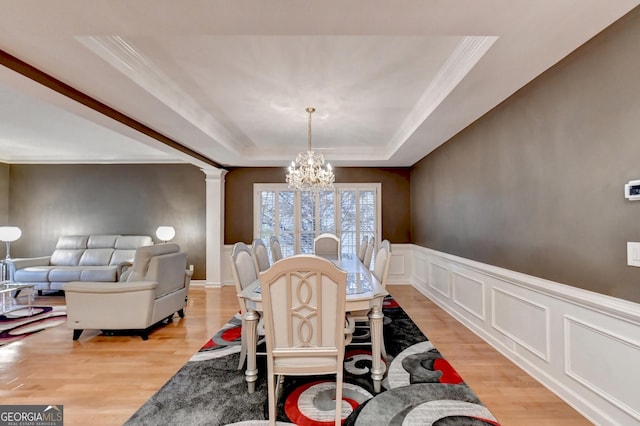 3565 Hickory Branch Trl, Suwanee, GA 30024 - dining area with a chandelier, a raised ceiling, light wood finished floors, ornamental molding, and decorative columns