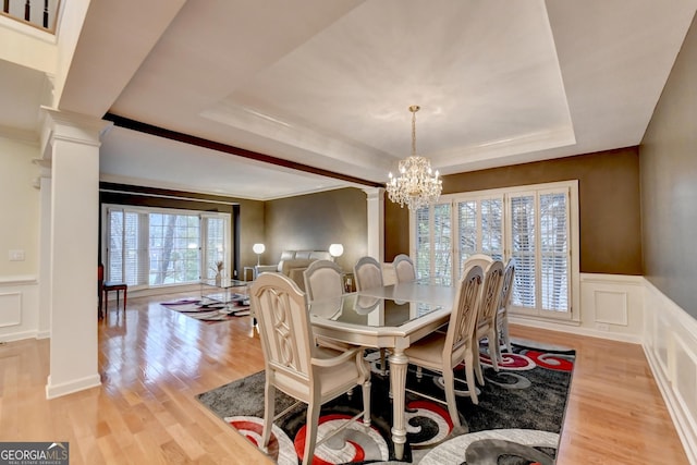 3565 Hickory Branch Trl, Suwanee, GA 30024 - dining area featuring decorative columns, a decorative wall, a raised ceiling, light wood-style floors, and a chandelier