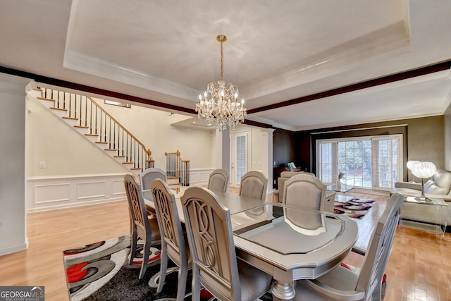 3565 Hickory Branch Trl, Suwanee, GA 30024 - dining room featuring light wood finished floors, a chandelier, stairs, ornamental molding, and a raised ceiling